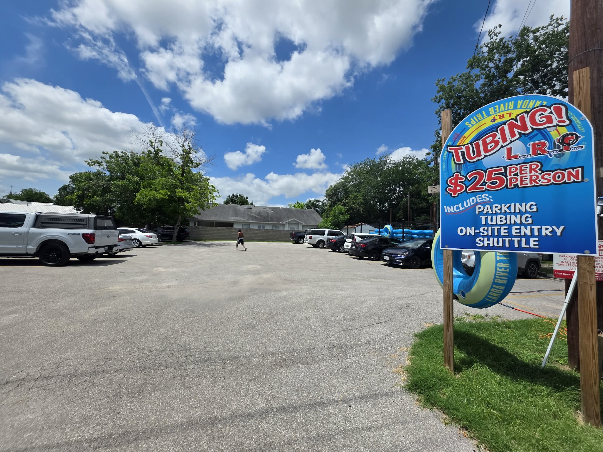 Landa River Trips tubing parking lot sign showing $25 per person includes parking tubing entry and shuttle New Braunfels Texas