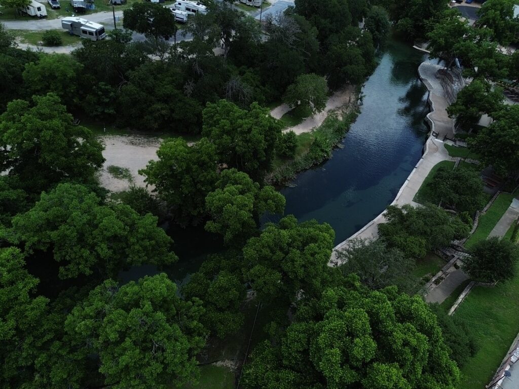 Aerial drone view of the Comal River and historic railroad bridge in New Braunfels Texas near Landa River Trips