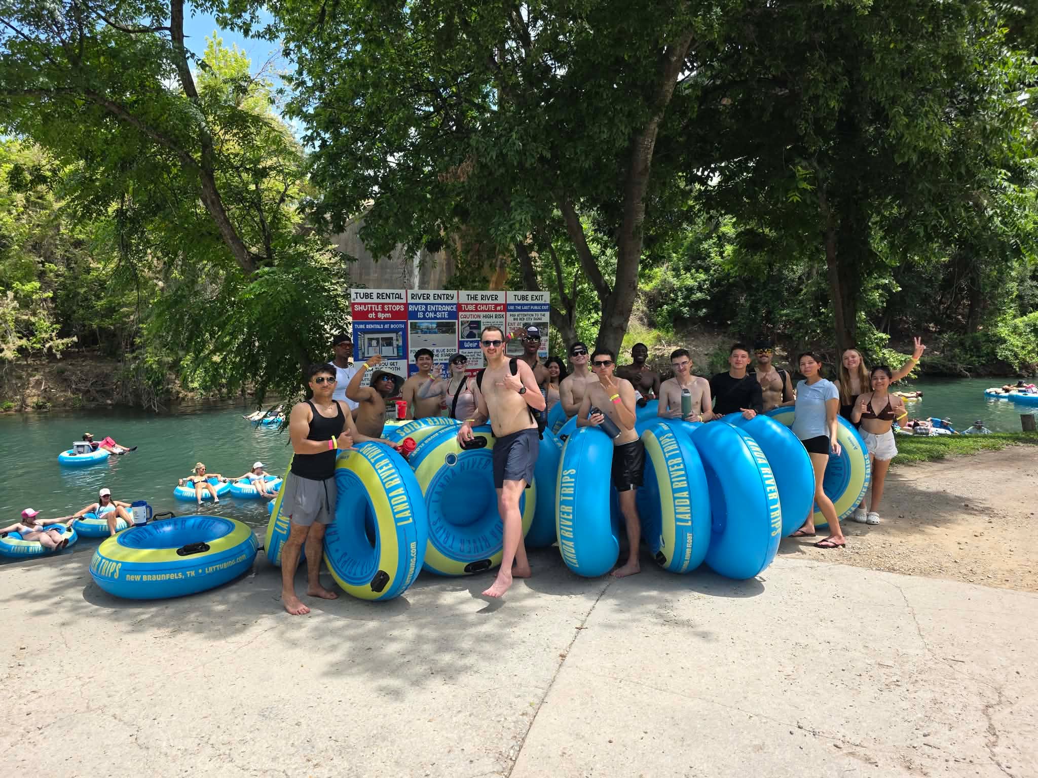 Comal River tubing FAQ New Braunfels guests at Landa River Trips with blue and yellow tubes ready to float